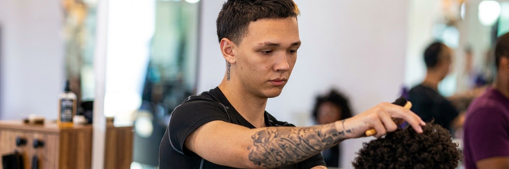 Jeremiah, known as YeeBlendz, combing out a client's curls at the barbershop