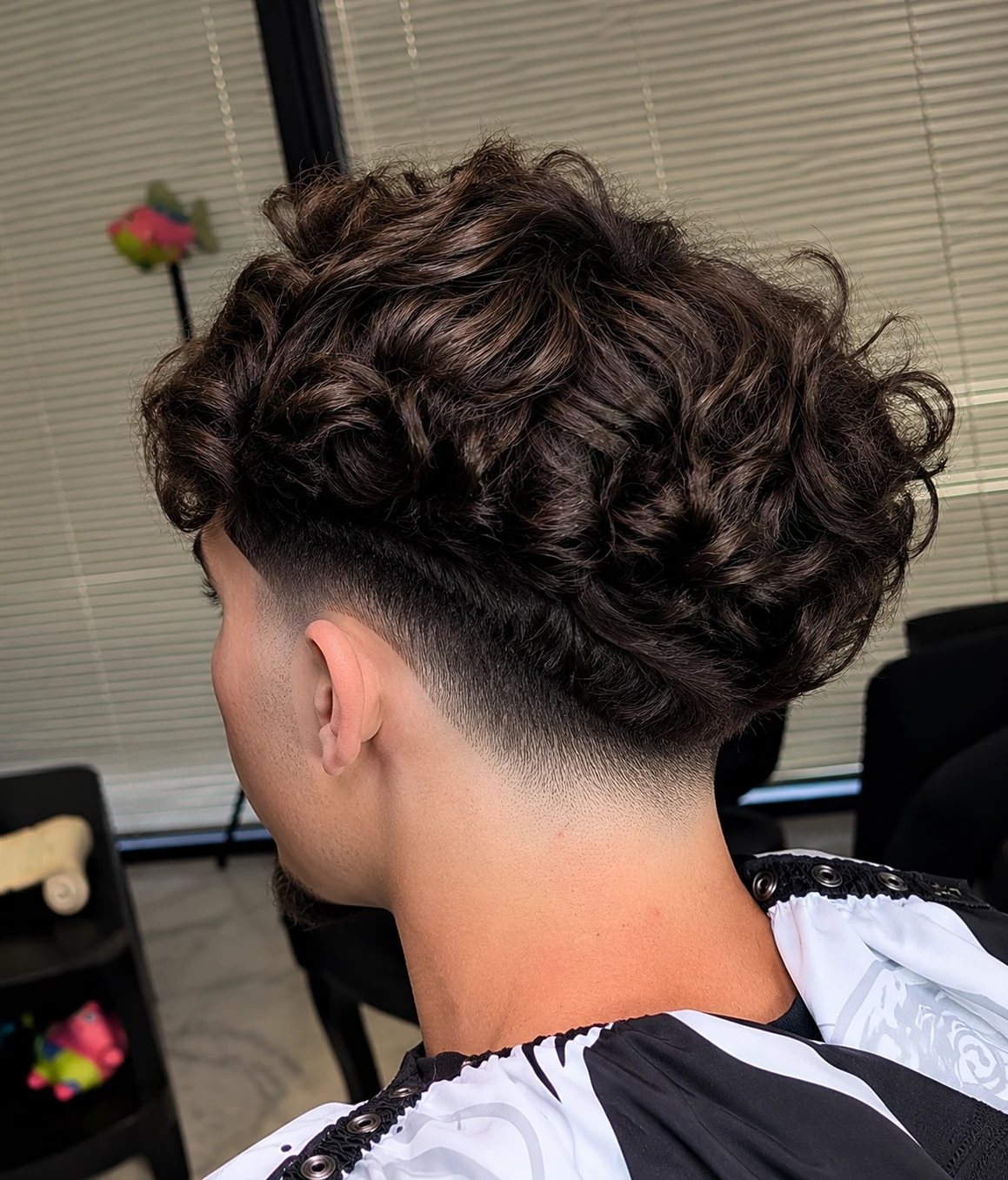 Curly top blended into a drop fade at the neckline